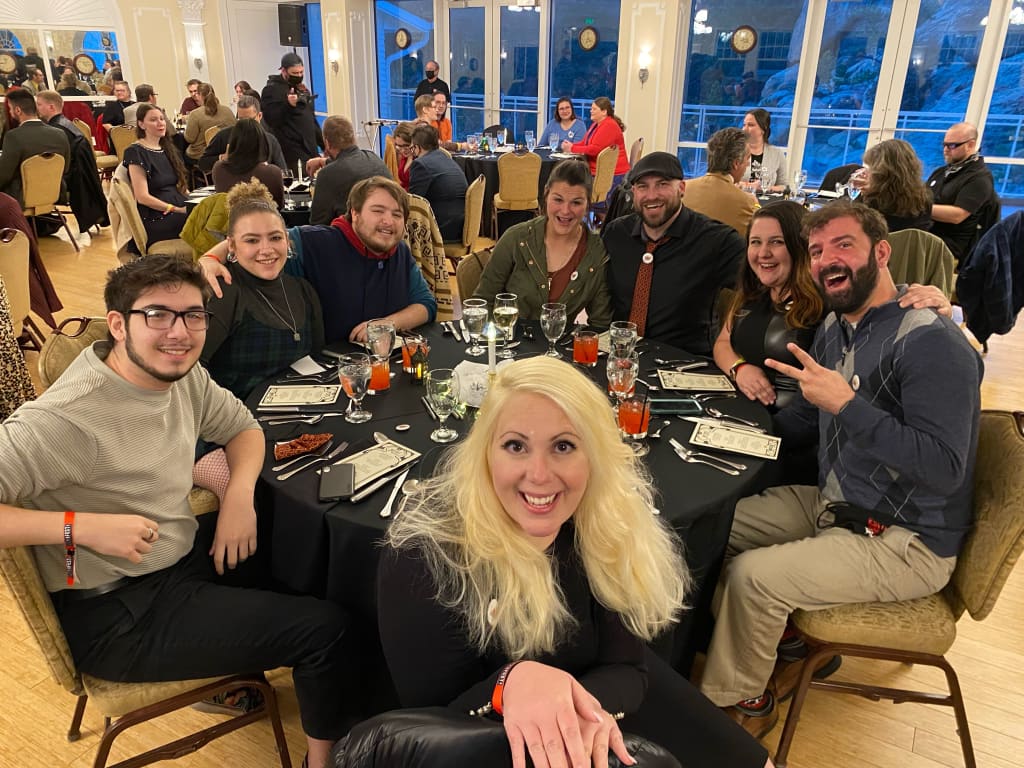 A group of people sit around a table during a dinner at the BRUCEFEST film festival