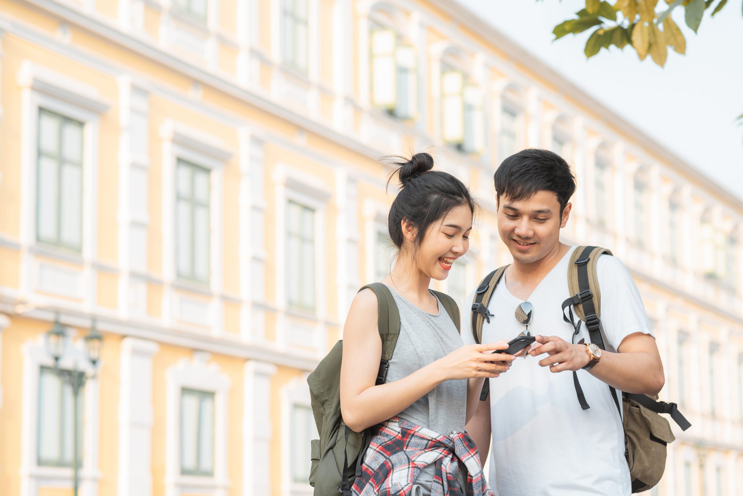 couple looking at phone in city using scavenger hunt app